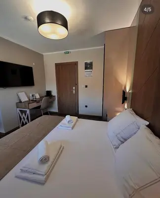 a large white bed in a room with a desk at Konačište u carstvu in Vrnjci