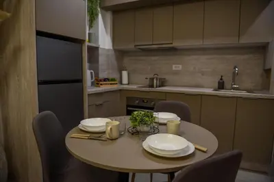 a kitchen with a table and chairs with plates on it at Apartman P Lux 2 Ćuprija in Ćuprija
