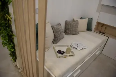 a small room with a couch with pillows and a tray at Apartman P Lux 2 Ćuprija in Ćuprija