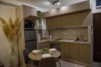 a kitchen with a table with chairs and a sink at Apartman P Lux 2 Ćuprija in Ćuprija