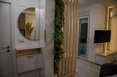 a living room with a door with a mirror and ivy at Apartman P Lux 2 Ćuprija in Ćuprija