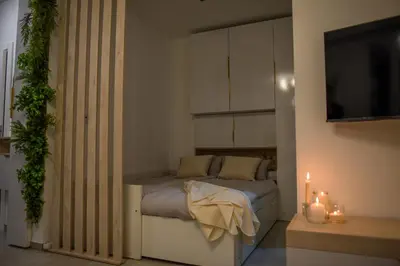 a bedroom with a bed with a television and candles at Apartman P Lux 2 Ćuprija in Ćuprija