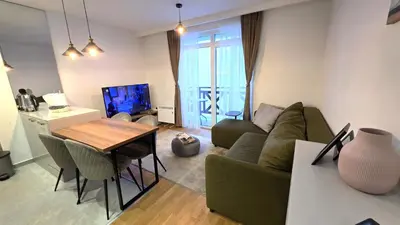 a living room with a green couch and a table at Sunny Hill Kop - Luxury Apartment Mountain View in Kopaonik