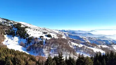 a view of a snowy mountain with trees and clouds at Sunny Hill Kop - Luxury Apartment Mountain View in Kopaonik
