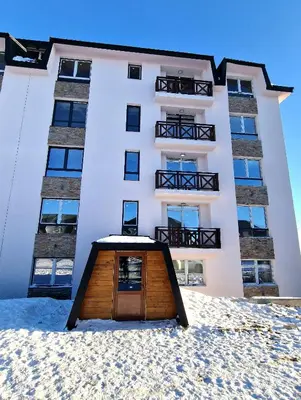 a building with a wooden door in front of it at Sunny Hill Kop - Luxury Apartment Mountain View in Kopaonik