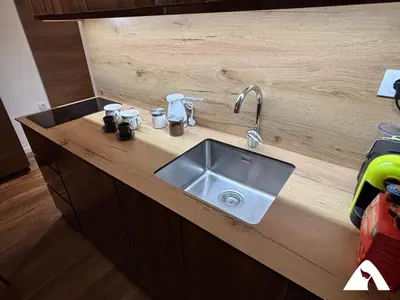 a kitchen counter with a sink in a wooden counter top at Apartman Herkul in Kopaonik