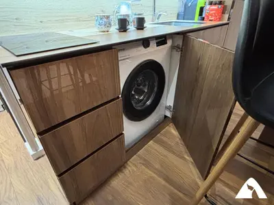 a washing machine under a counter in a kitchen at Apartman Herkul in Kopaonik