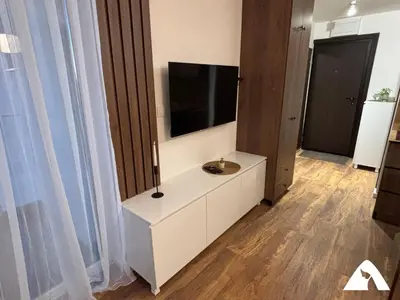 a living room with a television on a white cabinet at Apartman Herkul in Kopaonik