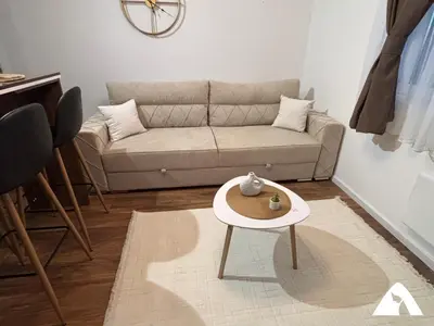 a living room with a couch and a table at Apartman Herkul in Kopaonik