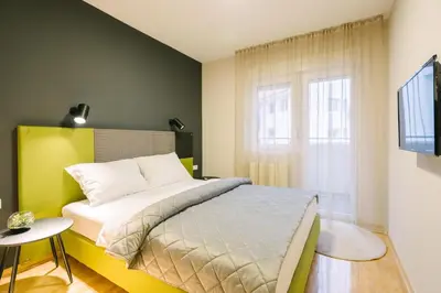 a bedroom with a bed and a window at NAR Royalton Apartment #60 Free Parking in Niš