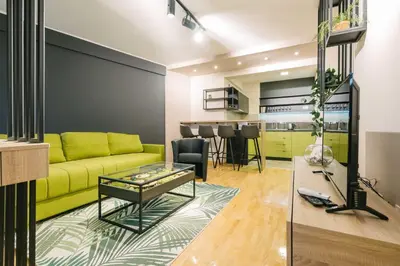 a living room with a yellow couch and a table at NAR Royalton Apartment #60 Free Parking in Niš