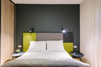 a bedroom with a large bed with two tables at NAR Royalton Apartment #60 Free Parking in Niš