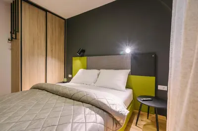 a bedroom with a bed with a yellow and black wall at NAR Royalton Apartment #60 Free Parking in Niš