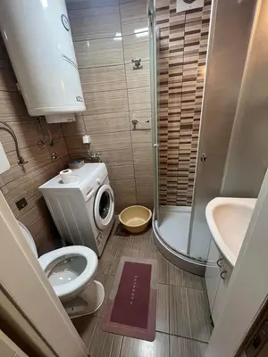 a small bathroom with a toilet and a shower at Stan u centru grada in Niš
