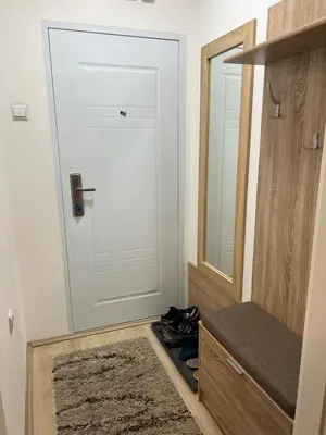 a bathroom with a door and a mirror and shoes at Stan u centru grada in Niš