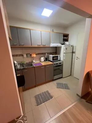 a small kitchen with a refrigerator and a stove at Stan u centru grada in Niš
