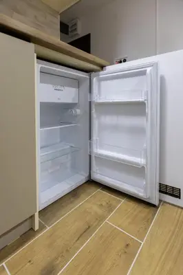 an empty refrigerator with its door open in a kitchen at Apartman Black Star Kop in Kopaonik