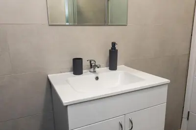 a bathroom with a white sink and a mirror at Apartman Black Star Kop in Kopaonik