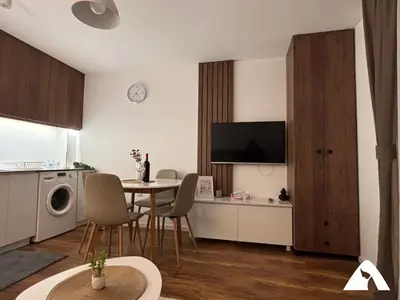 a kitchen and living room with a table and a dining room at Apartman Anči in Kopaonik