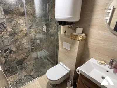 a bathroom with a toilet and a shower and a sink at Apartman Oliver in Kopaonik