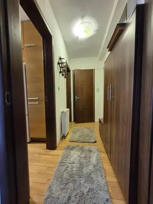 a hallway with wooden doors and rugs in a room at City Notes apartment in Niš