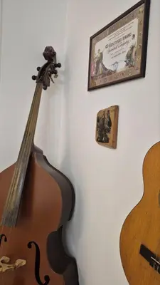 a guitar hanging on a wall next to a poster at City Notes apartment in Niš