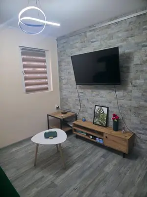 a living room with a flat screen tv on a brick wall at Black House Spa