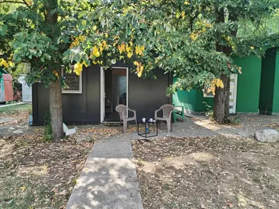 two chairs under two trees in front of a building at Black House Spa