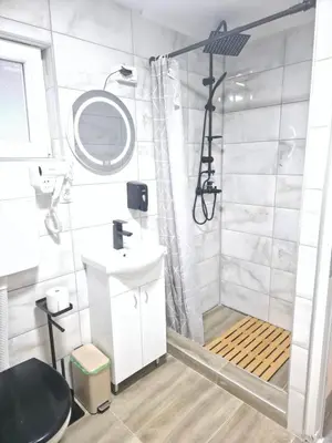 a white bathroom with a shower and a sink at Black House Spa