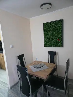 a dining room table with chairs and a painting on the wall at Black House Spa