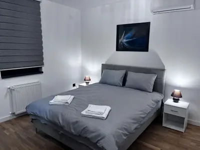 a bedroom with a bed with two towels on it at Cute Comfort Apartments in Niš