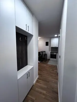 a hallway with white cabinets and a kitchen at Cute Comfort Apartments in Niš