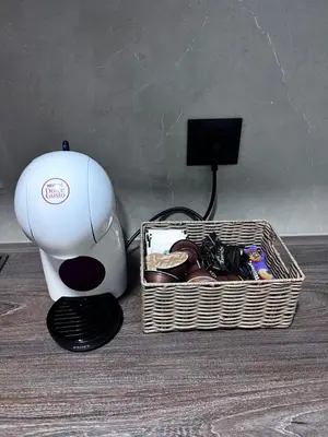a coffeemaker next to a basket of food and a box of chocolate at Cute Comfort Apartments in Niš