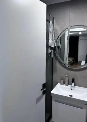 a bathroom with a white sink and a mirror at Cute Comfort Apartments in Niš