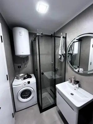 a bathroom with a washing machine and a sink at Cute Comfort Apartments in Niš