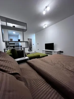 a bedroom with a bed and a flat screen tv at Cute Comfort Apartments in Niš