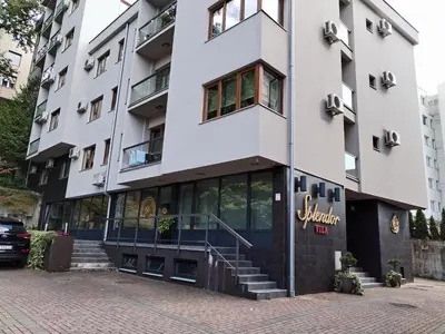 a large white building with a staircase in front of it at Apartman Besu in Vrnjačka Banja