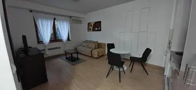 a living room with a table and chairs and a couch at Apartman Besu in Vrnjačka Banja