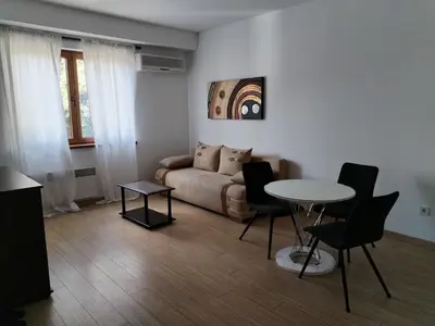 a living room with a couch and a table and chairs at Apartman Besu in Vrnjačka Banja