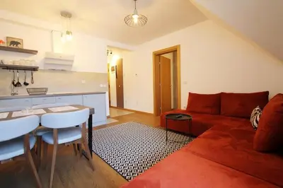 a living room with a red couch and a table at Nevena and Spa apartmans in Bukorovac