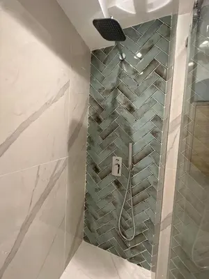 a bathroom with a shower with a tile wall at Vila Golija Sky View Kopaonik in Kopaonik