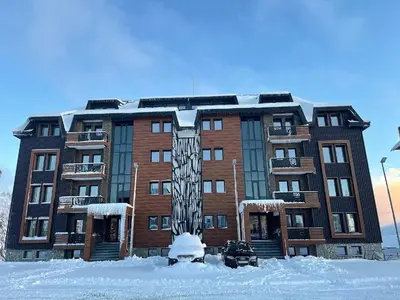 a large brick building with snow in front of it at Vila Golija Sky View Kopaonik in Kopaonik