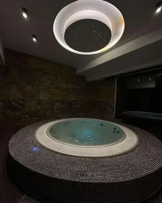 a large tub in a bathroom with a large light fixture at Vila Golija Sky View Kopaonik in Kopaonik