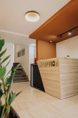 a lobby with a reception counter and stairs at Gallus Inn in Aleksinac