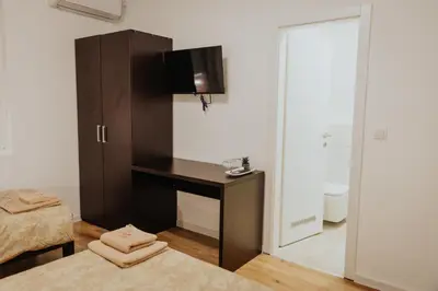 a bedroom with a desk and a tv on a wall at Gallus Inn in Aleksinac