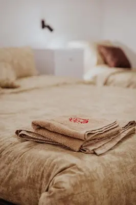 a pile of towels sitting on top of a bed at Gallus Inn in Aleksinac