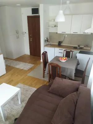 a living room and kitchen with a couch and a table at Apartman Pogled Lux - Green Hill Sokobanja in Soko Banja