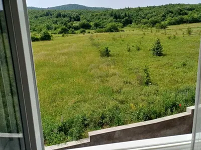 a view of a field of grass from a window at Apartman Pogled Lux - Green Hill Sokobanja in Soko Banja