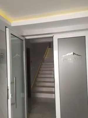 a staircase in a building with a glass door and stairs at Apartman Pogled Lux - Green Hill Sokobanja in Soko Banja