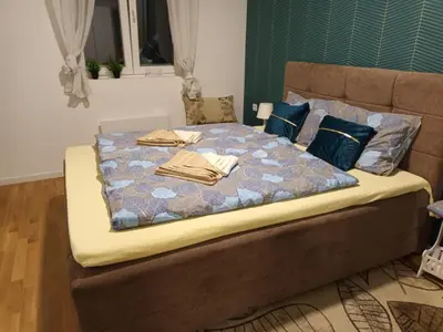 a large bed with blankets and pillows on it at Apartman Pogled Lux - Green Hill Sokobanja in Soko Banja